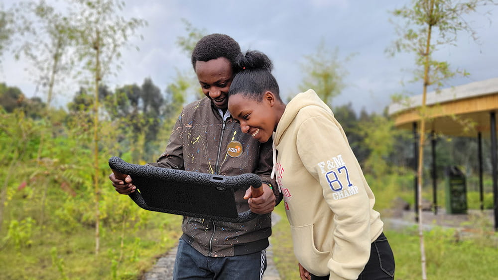 Visitors explore the GorillAR augmented reality trek on campus using a custom-designed iPad case, sharing the experience together outdoors.